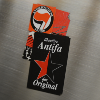 Schwarzer Aufkleber mit Aufschrift "libertäre Antifa das Original" und einem rot / schwarzen Stern