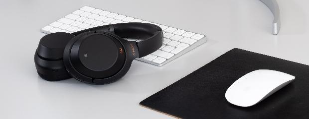 Graue Tastatur und graue Maus zusammen mit einem schwarzen Kopfhörer. Graue Tastatur und graue Maus zusammen mit einem schwarzen Kopfhörer.