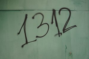 Graffiti Zahl 1312 schwarz auf weiß-grauer Wand