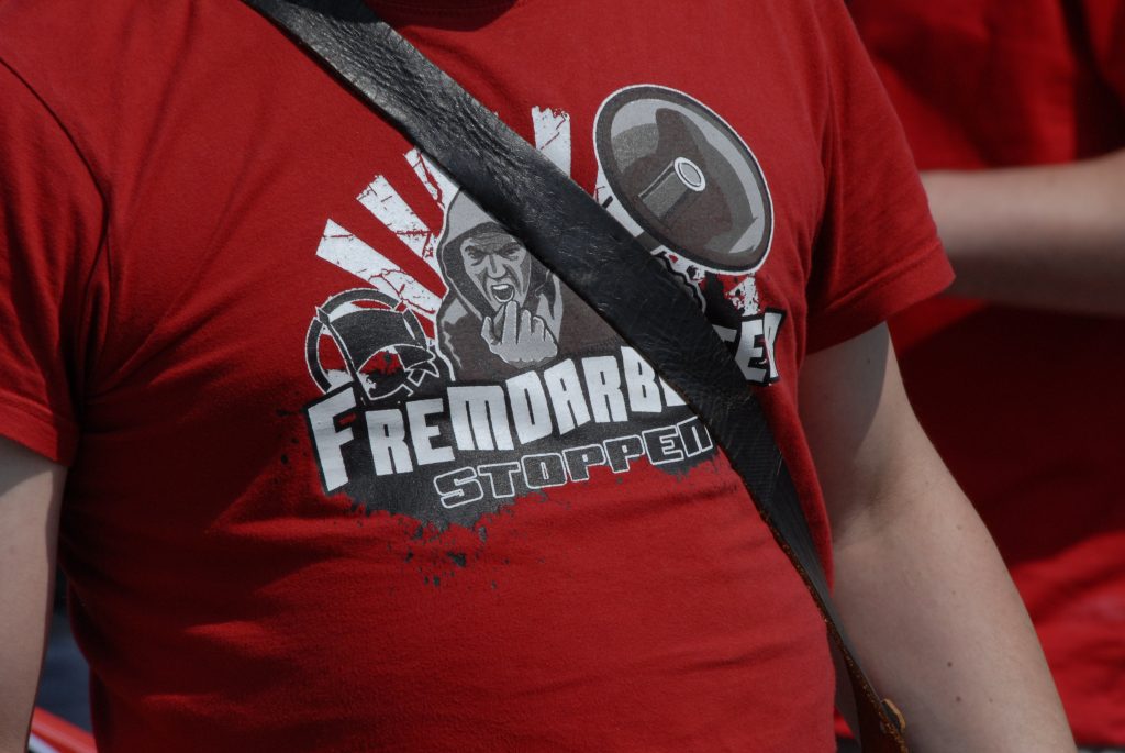 Foto eines Rechtsextremisten, der ein T-Shirt trägt mit der Aufschrift "Fremdarbeiter stoppen"