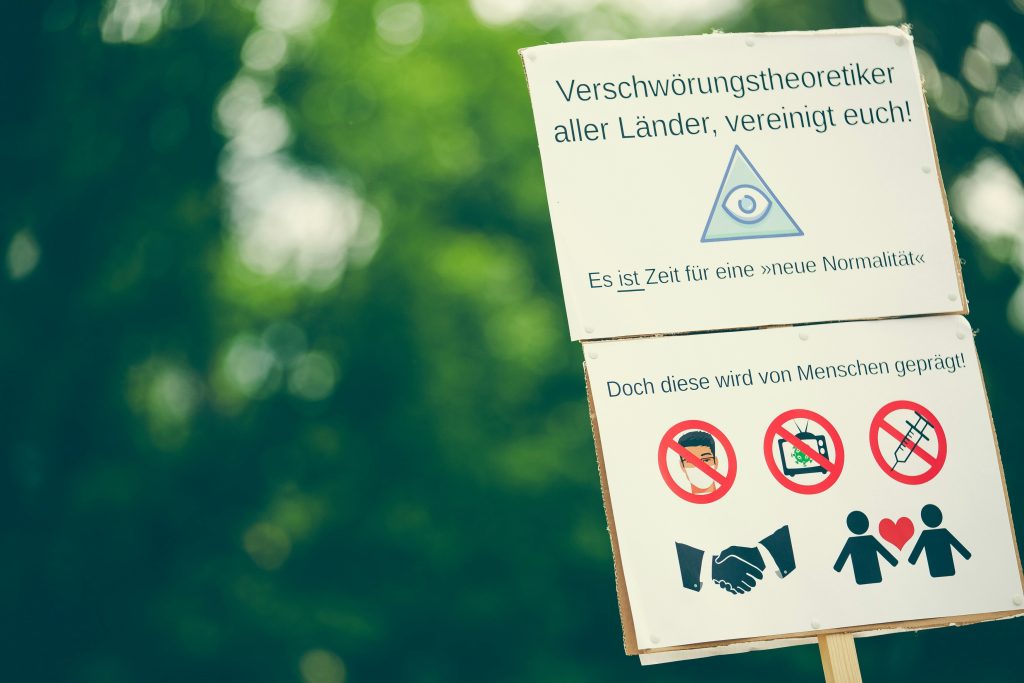 Ein Schild mit Kritik an staatlichen Infektionsschutzmaßnahmen wird auf einer Kundgebung in der Corona-Zeit auf der Wöhrder Wiese in Nürnberg im Juni 2020 hochgehalten.
