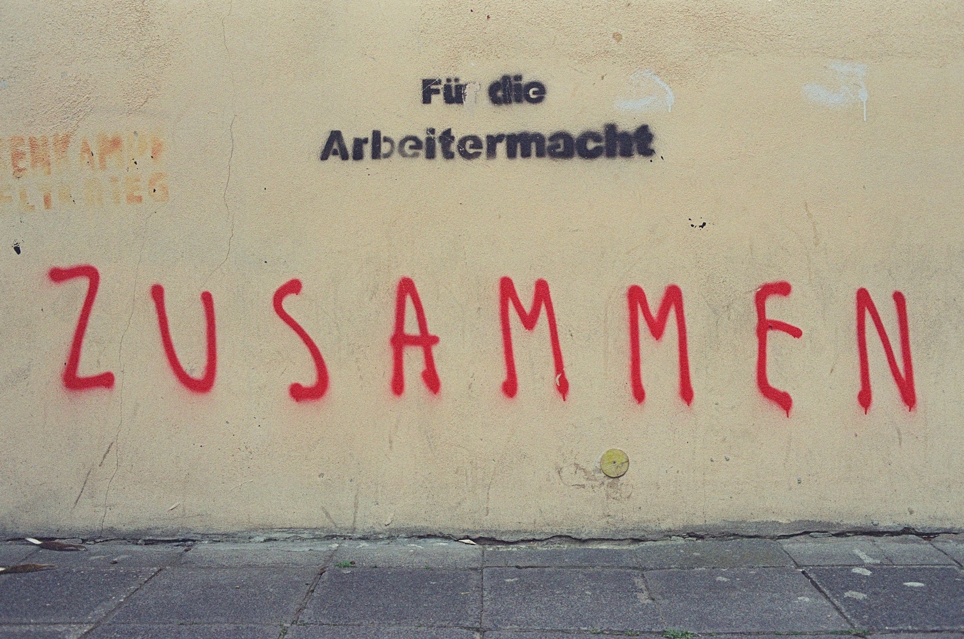 Eine Wand mit Graffiti. Der Text lautet Zusammen für die Arbeitermacht.